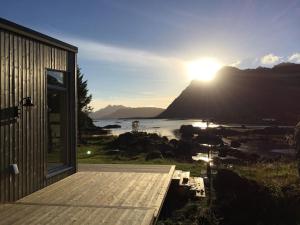 una casa con il sole che tramonta su una montagna di Gammelstua Seaview Lodge a Kongsjorda