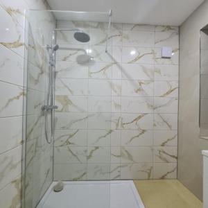 y baño con ducha y azulejos de mármol. en 3 bedroom home - Meadowhall, Magna, Utilita arena, free parking, garden, en Templebrough