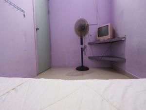 a purple room with a fan and a tv at SPOT ON 93276 Fendi 2 Homestay Syariah in Nagoya