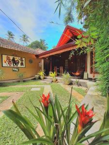 a house with red flowers in front of it at Thara Cabana in Bentota