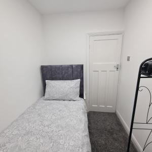 a bedroom with a bed with a pillow and a door at 3 bedroom home - Meadowhall, Magna, Utilita arena, free parking, garden in Templebrough