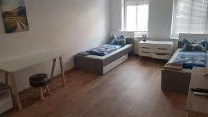 a room with two beds and a desk in it at Rockys Ferienwohnung Mitte in Markkleeberg