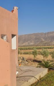 a building in the desert with a view of the mountains at Ferme Jnan Al Yassmine in Taza