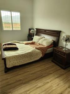 ein Schlafzimmer mit einem Bett, einem Nachttisch und einem Fenster in der Unterkunft Ferme Jnan Al Yassmine in Taza