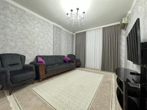salon z 2 kanapami i telewizorem w obiekcie Жк Керуен Сарай w mieście Türkistan