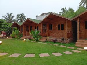 a house with a grass yard in front of it at TP cottages Beach Resort in Arambol
