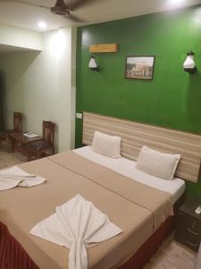 ein Schlafzimmer mit einem großen Bett und einer grünen Wand in der Unterkunft TP cottages Beach Resort in Arambol