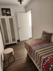 Un dormitorio con una cama y un taburete. en Anna's apartments, en Alicante