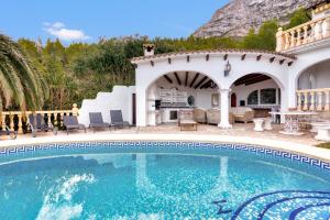 una piscina con patio y una casa en Villa Lau Costa Blanca en Dénia