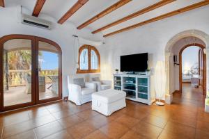 a living room with a couch and a tv at Villa Lau Costa Blanca in Denia