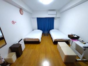 a small room with two beds and a desk at Comfort CUBE PHOENIX S KITATENJIN in Fukuoka