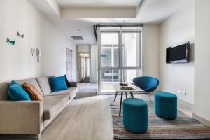 a living room with a couch and blue chairs at Collins Street Blues - Stay in the Heart of it All in Melbourne
