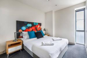 1 dormitorio con 1 cama con cabecero grande en Collins Street Blues - Stay in the Heart of it All en Melbourne