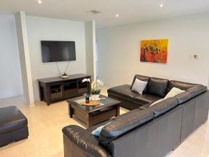 a living room with a couch and a tv at Premium Barossa Getaway in Tanunda