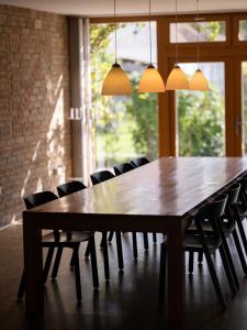 a large wooden table with chairs and lights at Weingut & Gästezimmer Zillinger in Ebenthal