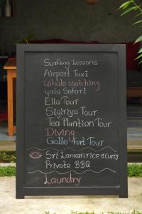 een bord met een bord met een menu voor een restaurant bij Temple Tree in Weligama