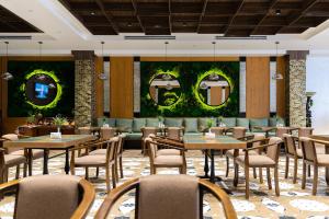 a dining room with tables and chairs and mirrors at Shamsan Airport Hotel in Tashkent