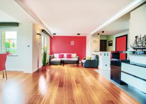 salon z czerwonymi ścianami i kanapą w obiekcie Happiness House Balcony & Nice Garden w Gdańsku