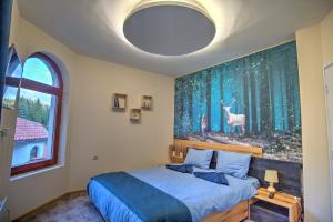 een slaapkamer met een bed met een schilderij aan de muur bij Вила Capitalica Forte in Pamporovo