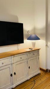 un televisor en la parte superior de un tocador con una lámpara en él en gemütliche Wohnung, en Bad Schwartau