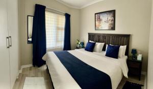 1 dormitorio con 1 cama grande con almohadas azules en Nautica 403, en Strand