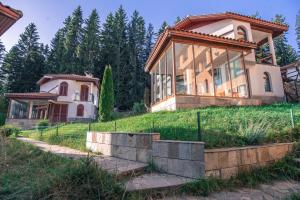 a house on top of a hill with trees at Вила Capitalica Forte in Pamporovo