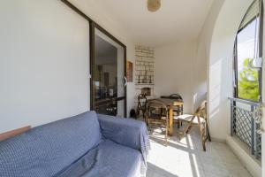 a living room with a blue couch and a table at Flat with Balcony 3 min to Fosforlu Beach in Antalya