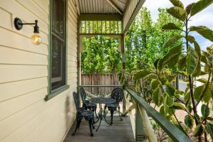 porche con sillas, mesa y ventana en Heritage on Fairview - Classic Comfort in Geelong en Geelong