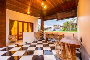 a patio with a table and chairs on a checkered floor at The Nest Canggu in Canggu
