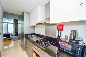 a kitchen with a stove top oven next to a sink at Canal View Studio Apartments - DAMAC Prive Business Bay in Dubai