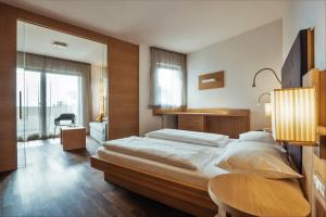 a bedroom with a large bed and a table at Hilburger Hotel in Schenna