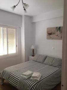 a bedroom with a bed with two towels on it at Apartamento a 5 min de la playa y el centro in Almería