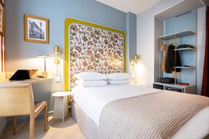 a hotel room with a bed and a desk and a desk at Mercure Paris Notre Dame Saint Germain des Prés in Paris