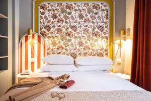 a bed with a headboard with a pair of scissors on it at Mercure Paris Notre Dame Saint Germain des Prés in Paris