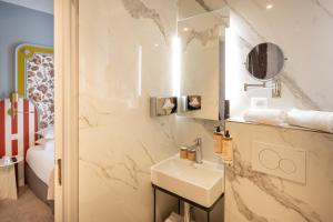 La salle de bains est pourvue d'un lavabo et d'un miroir. dans l'établissement Mercure Paris Notre Dame Saint Germain des Prés, à Paris