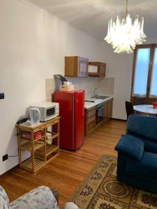eine Küche mit einem roten Kühlschrank und einer Mikrowelle in der Unterkunft Appartamento - Châtillon in Châtillon