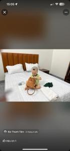 lalka siedząca na łóżku w obiekcie Hotel Minh Thắng w mieście Nho Quan