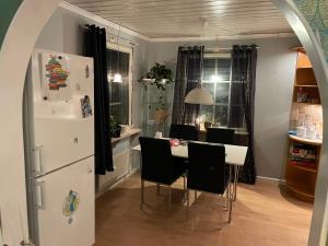 eine Küche und ein Esszimmer mit einem Tisch und einem Kühlschrank in der Unterkunft Little adorable red in Kiruna