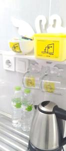 - un réfrigérateur avec des bouteilles d'eau et une bouilloire dans l'établissement OYO 93286 Yellow House Syariah, à Bogor