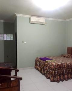 een slaapkamer met een bed in een kamer bij OYO 93286 Yellow House Syariah in Bogor