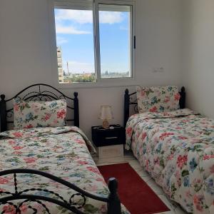1 Schlafzimmer mit 2 Betten und einem Fenster in der Unterkunft résidence kaoutare in Meknès