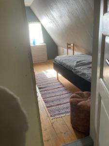 um quarto no sótão com uma cama e um tapete em Daltorp - äldre, charmigt hus på landet em Brunflo