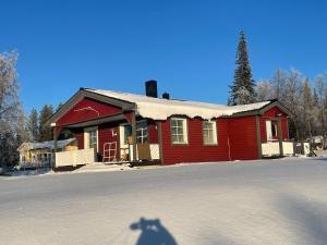 ein rotes Haus mit Schnee auf dem Dach davor in der Unterkunft Little adorable red in Kiruna