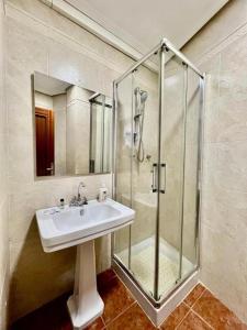 a bathroom with a sink and a glass shower at VIVIENDA REAL CON ENCANTO in Úbeda