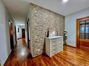 a living room with a brick wall and a dresser at VIVIENDA REAL CON ENCANTO in Úbeda