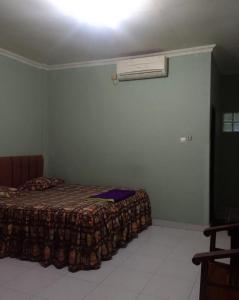 een slaapkamer met een bed met een deken erop bij OYO 93286 Yellow House Syariah in Bogor