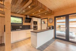 a kitchen with a counter and a large window at Almdorf Hohentauern by ALPS RESORTS in Hohentauern