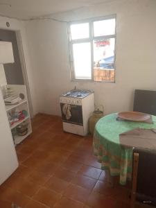 a kitchen with a table and a stove and a window at Rocinha House in Rio de Janeiro