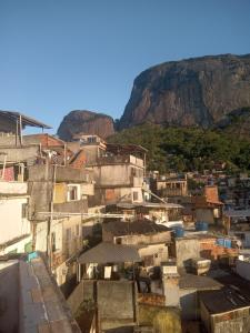 un gruppo di edifici con una montagna sullo sfondo di Rocinha House a Rio de Janeiro