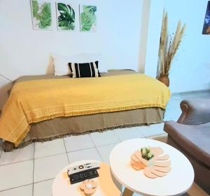 a bedroom with a bed with a yellow blanket and a table at CASA CÉNTRICA RIOJA ,Patio Parrilla, Zona Residencial, Parking privado gratis a 100 mts in Mendoza